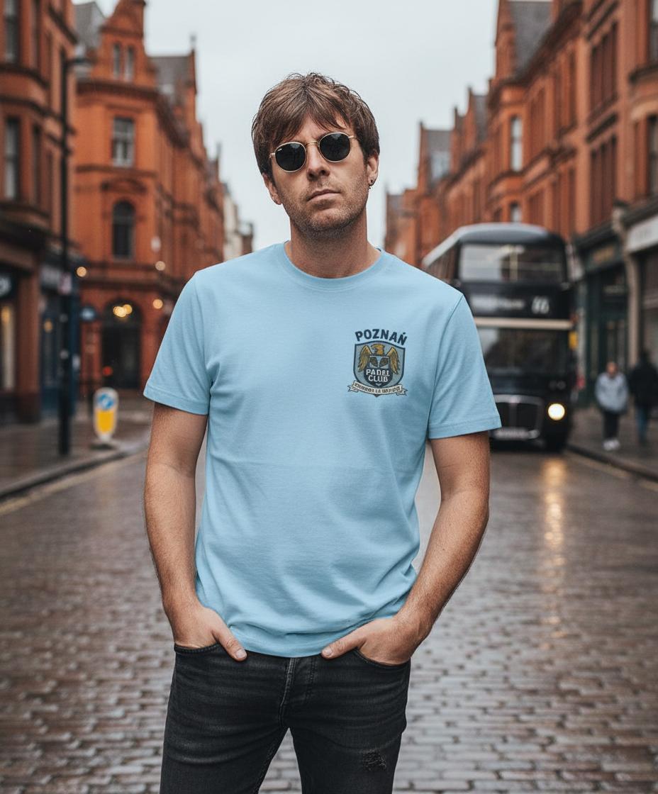 Man wearing a light blue Poznan Padel t-shirt with a logo on a city street